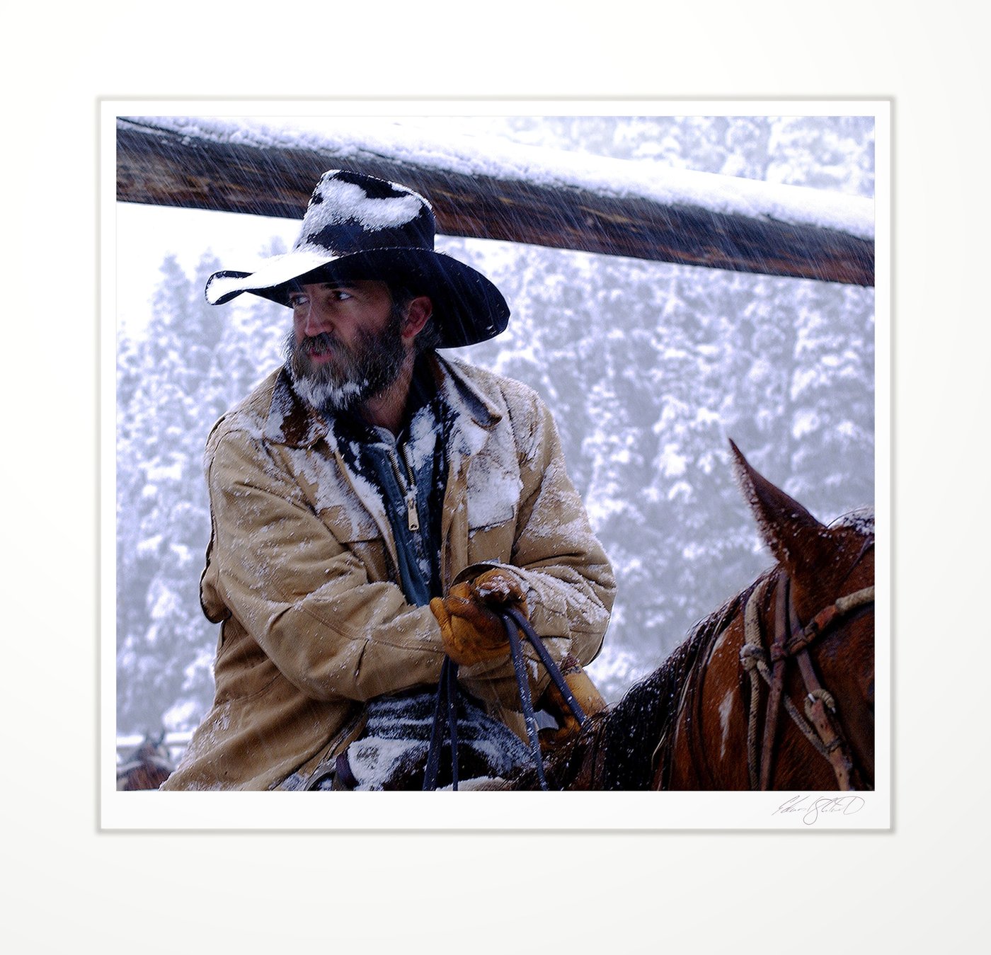 A cowboy on horseback in a heavy snowstorm