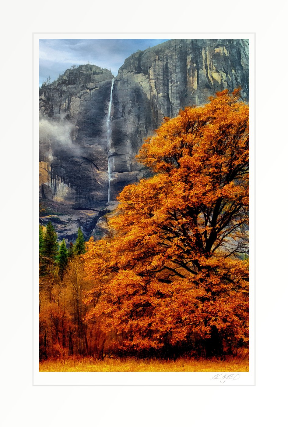 Yosemite Falls cascading down a granite cliff, framed by an autumn tree in the foreground