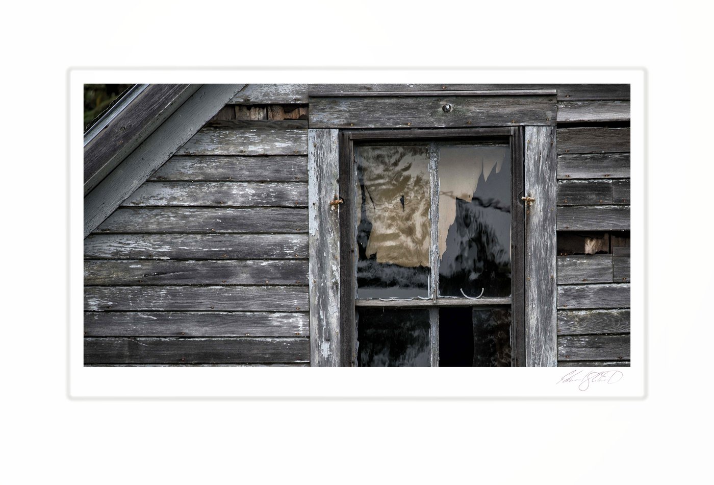 A weathered farmhouse window with peeling paint and broken glass