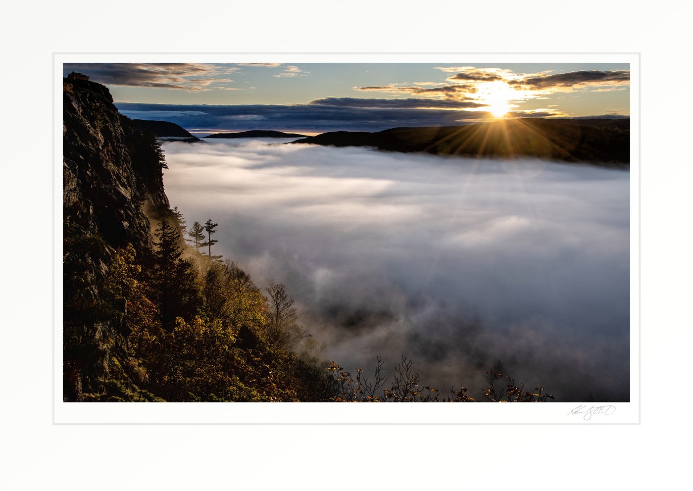Sunrise breaking over a fog-filled valley at Lake of the Clouds in the Porcupine Mountains