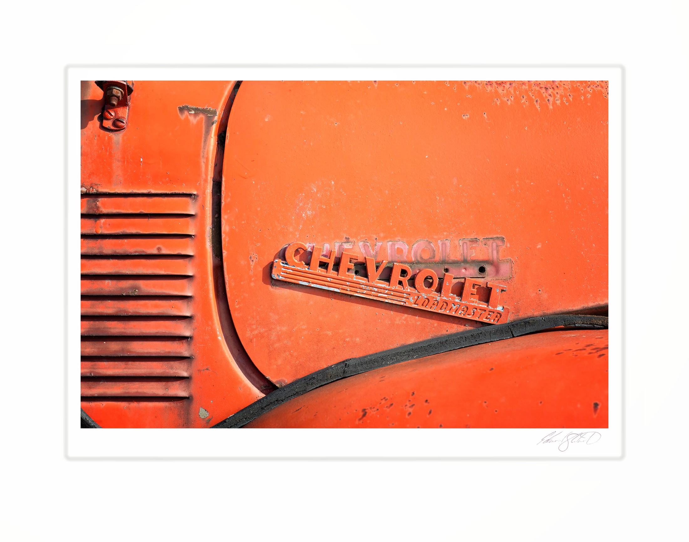 A close-up of a rusted orange Chevrolet Loadmaster emblem