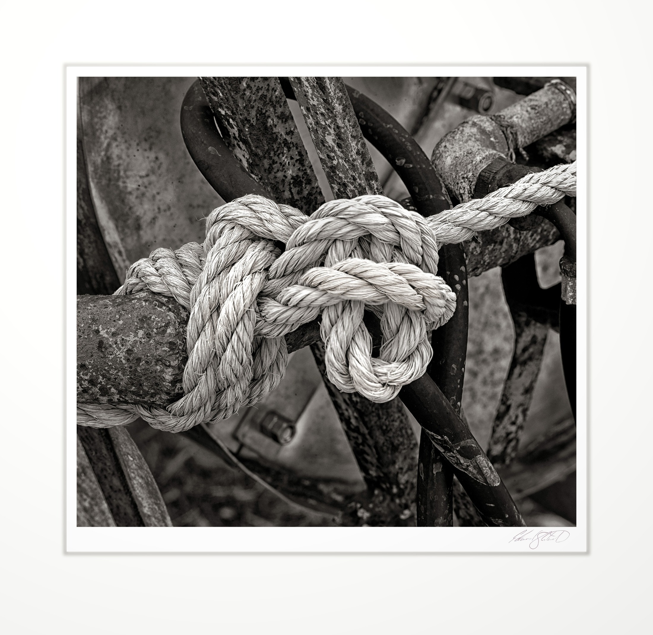 A rope knot tied to rusted machinery