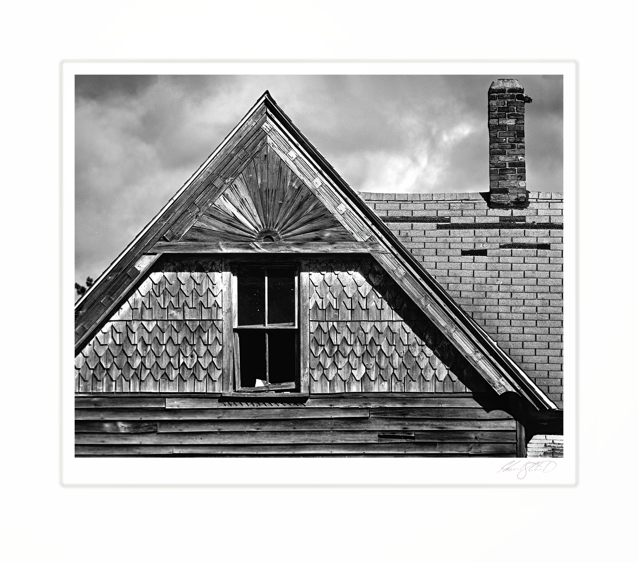 The gabled roofline and chimney of an old farmhouse.